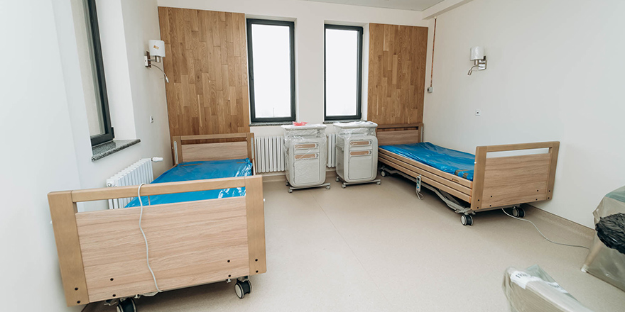Zwei Krankenhausbetten in Buchenholzoptik.