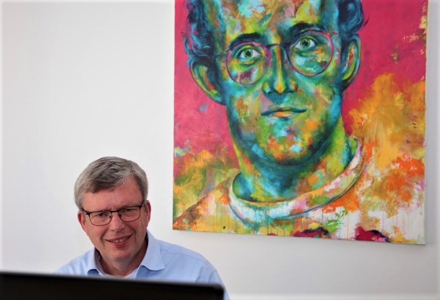 Anlageberater Gerhard Winkels vor einem Porträt des Künstlers Keith Haring, ebenfalls gemalt von der Aachener Künsterlin Kascho.